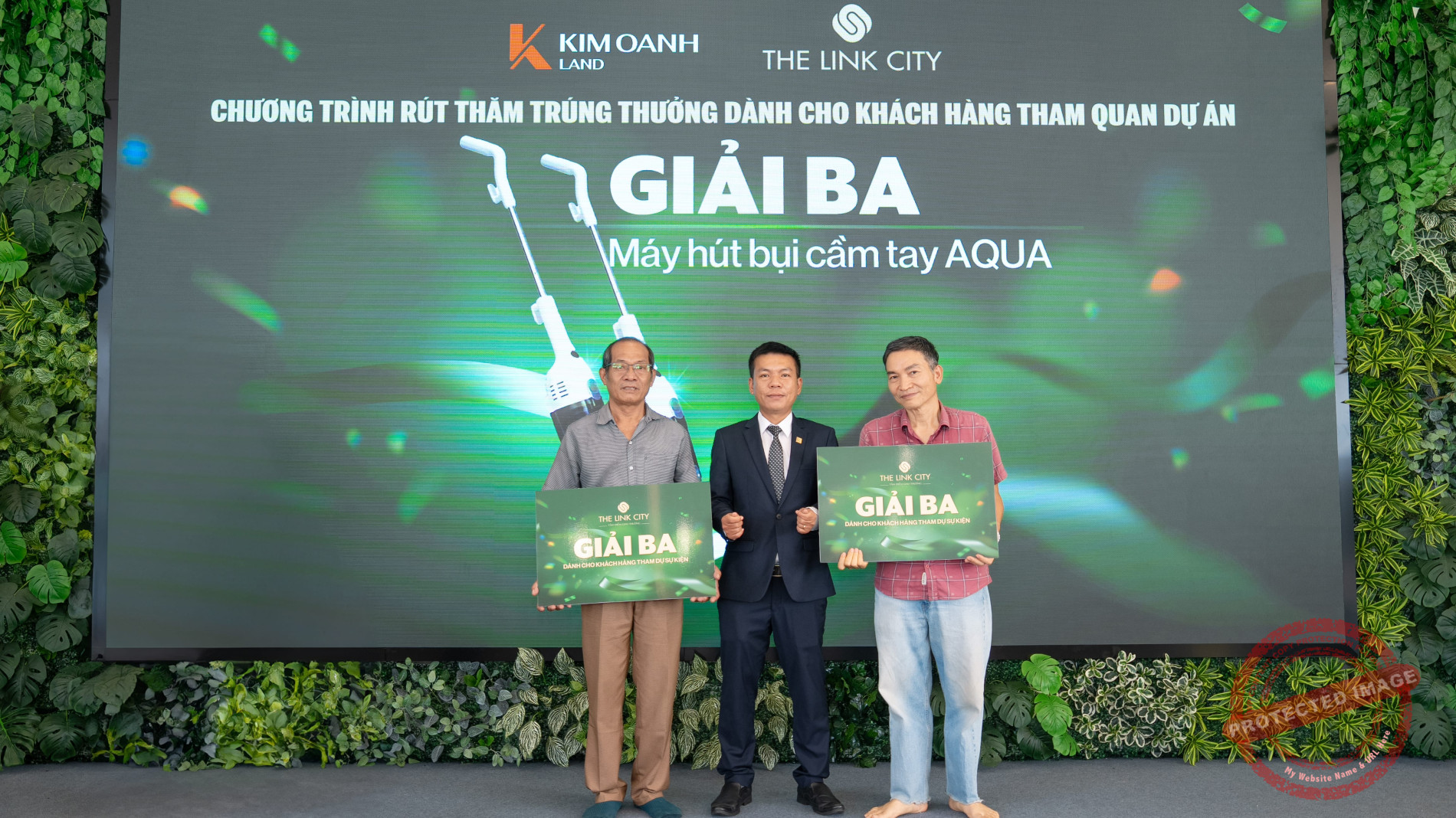 Ông Phạm Tấn Sự - Giám đốc Chi nhánh Phạm Văn Đồng trao giải Ba là máy hút bụi cầm tay AQUA đến 2 khách hàng tham quan dự án.