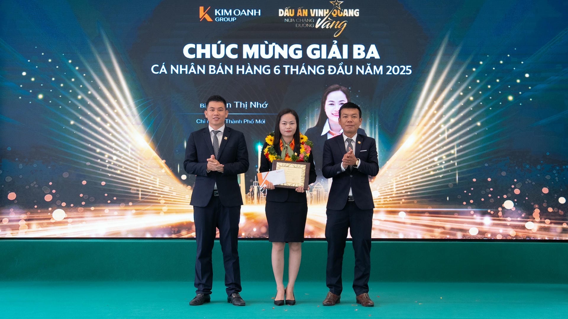 Ông Trịnh Thanh Tuấn – Giám đốc Chi nhánh Điện Biên Phủ và ông Nguyễn Tấn Sự – Giám đốc Chi nhánh Phạm Văn Đồng trao Giải Ba - Cá nhân bán hàng 6 tháng đầu năm 2025 cho bà Phan Thị Nhớ - Nhóm 3 - Phòng 1 - Chi nhánh Thành Phố Mới.